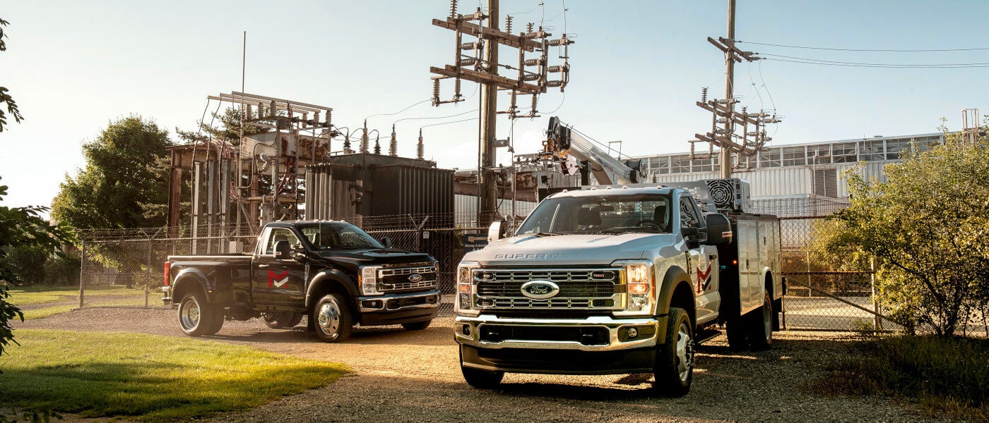 2026 Ford Super Duty F-350 pair parked outside a power plant